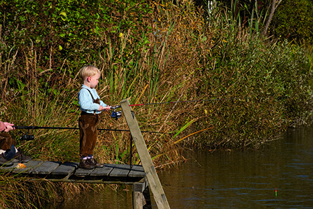 Kleiner Bub in Lederhose beim Fischen